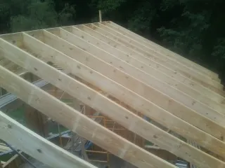 New roof rafters set over an addition before sheathing in Peyton