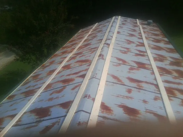 Rusted metal roof panels with new wood purlins before replacement — Storm Damage Roof Repair in Peyton by Roofing Brothers