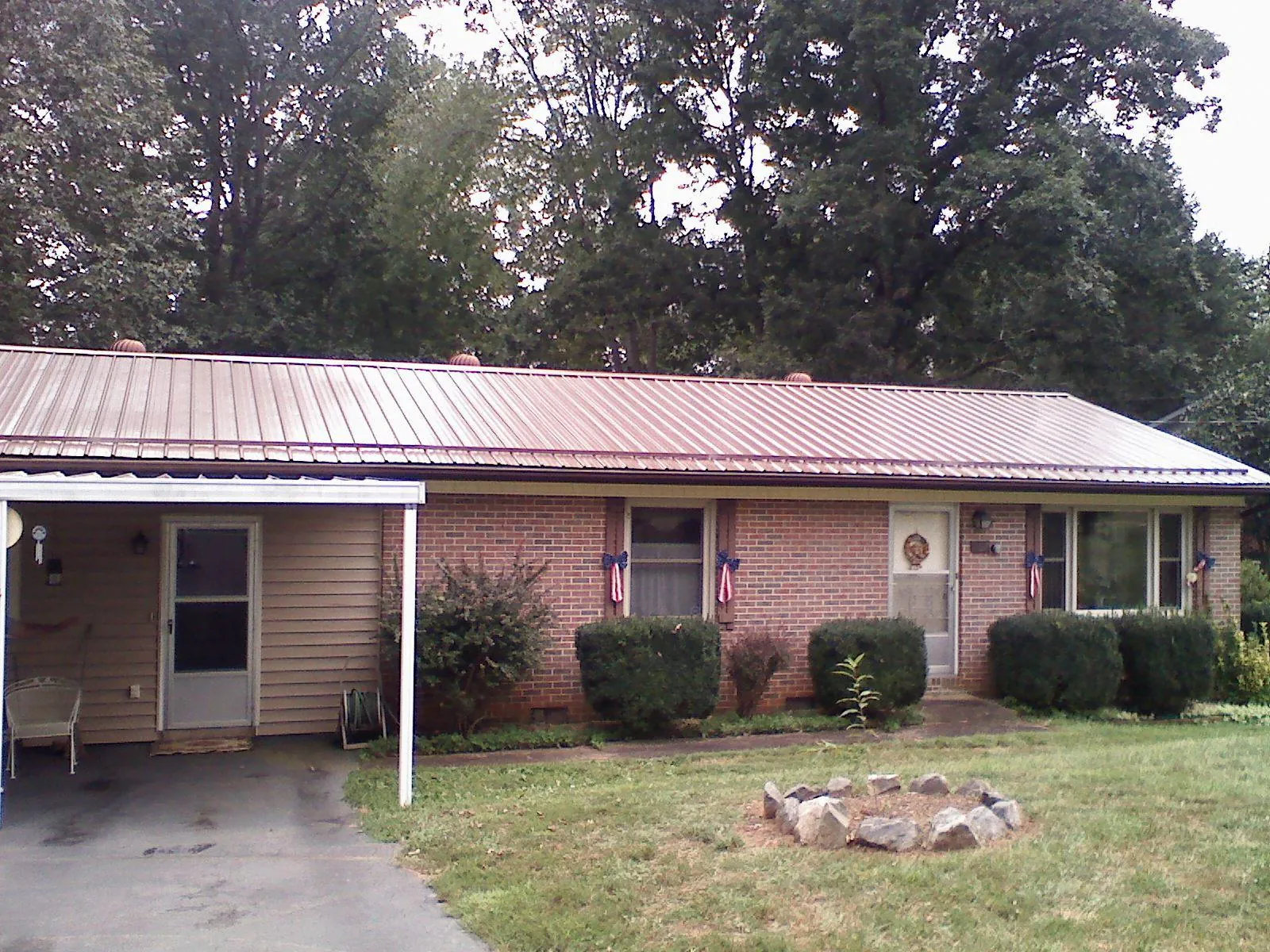 Bronze metal roof and carport on a brick ranch home — Roof Repair work by our crew in Peyton